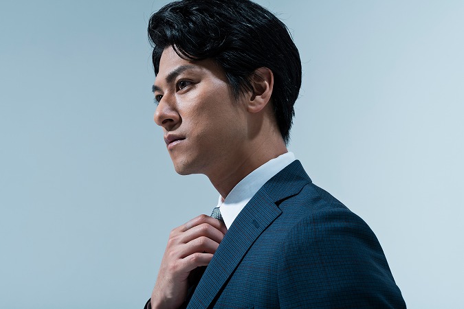 ネクタイを正す男性